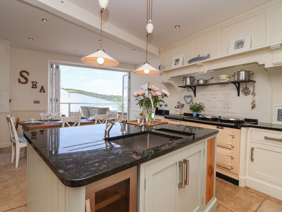 A kitchen with an island, stove, and dining area at Marina in 