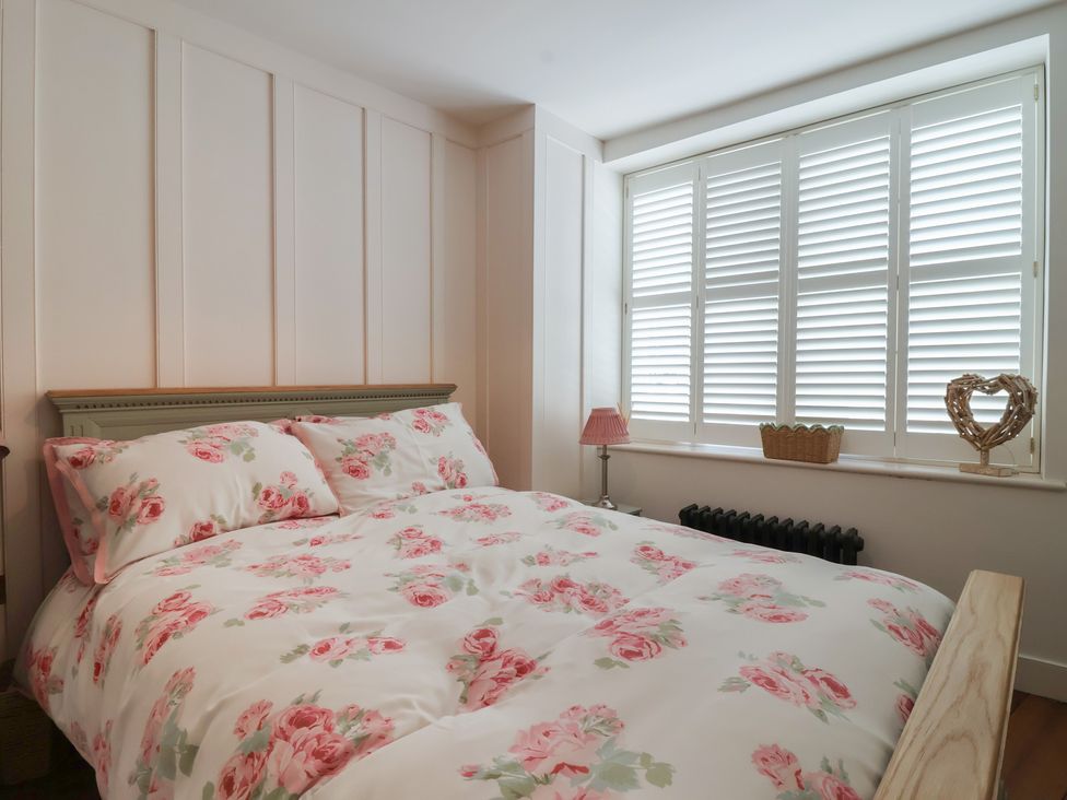 A bedroom with a bed and floral bedding at Marina