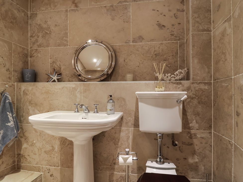 A bathroom with a sink, toilet, and mirror at Marina