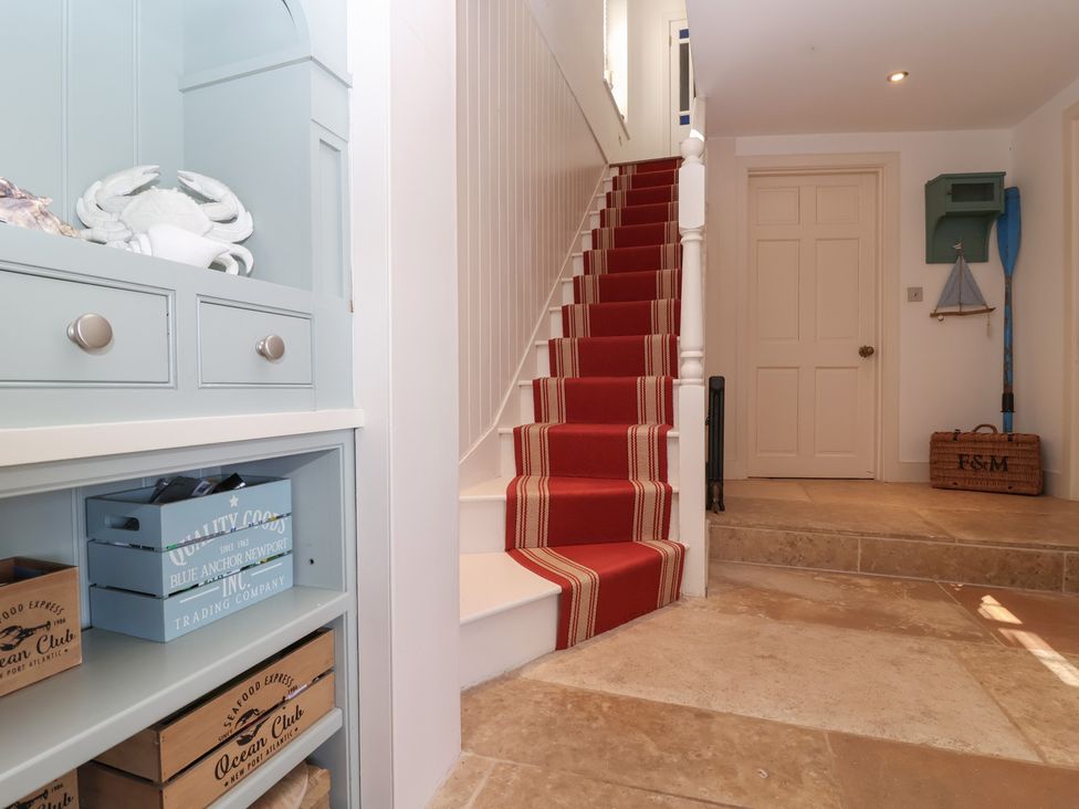 A hallway with a staircase and storage boxes at Marina