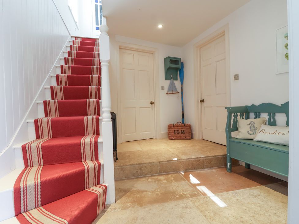 A hallway with stairs and a green bench at Marina