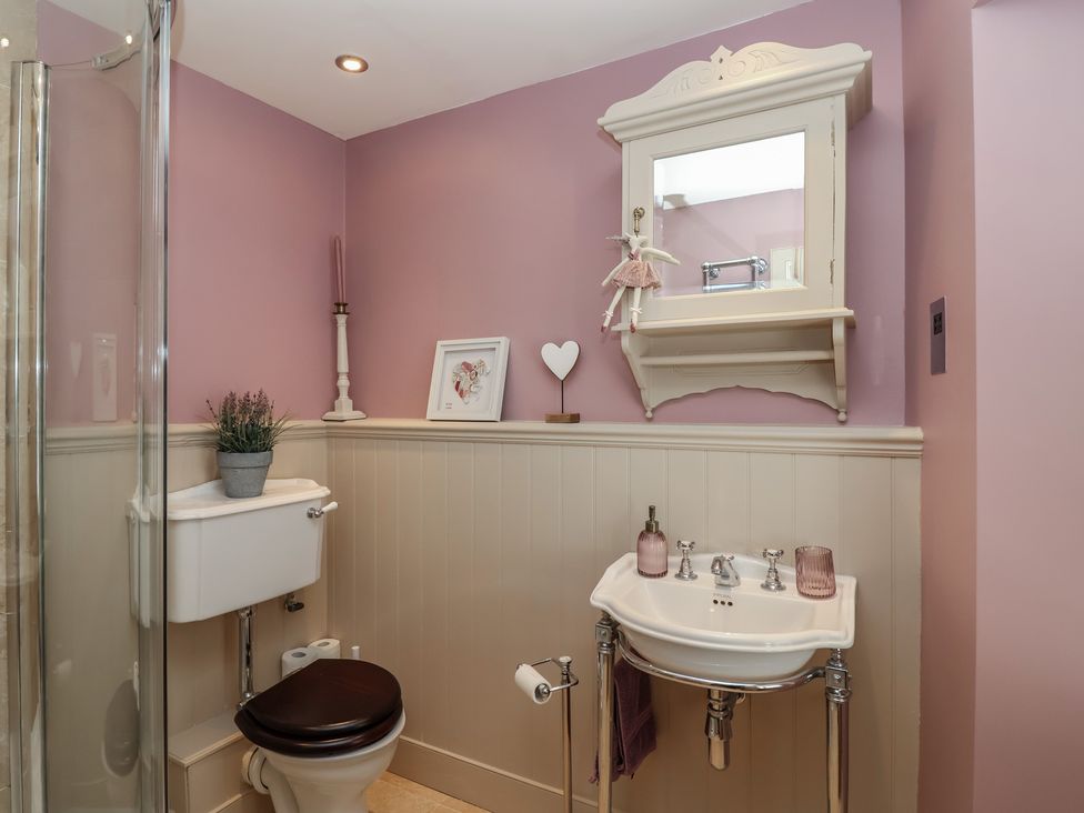 A bathroom featuring a sink, toilet, shower, and mirror at Marina