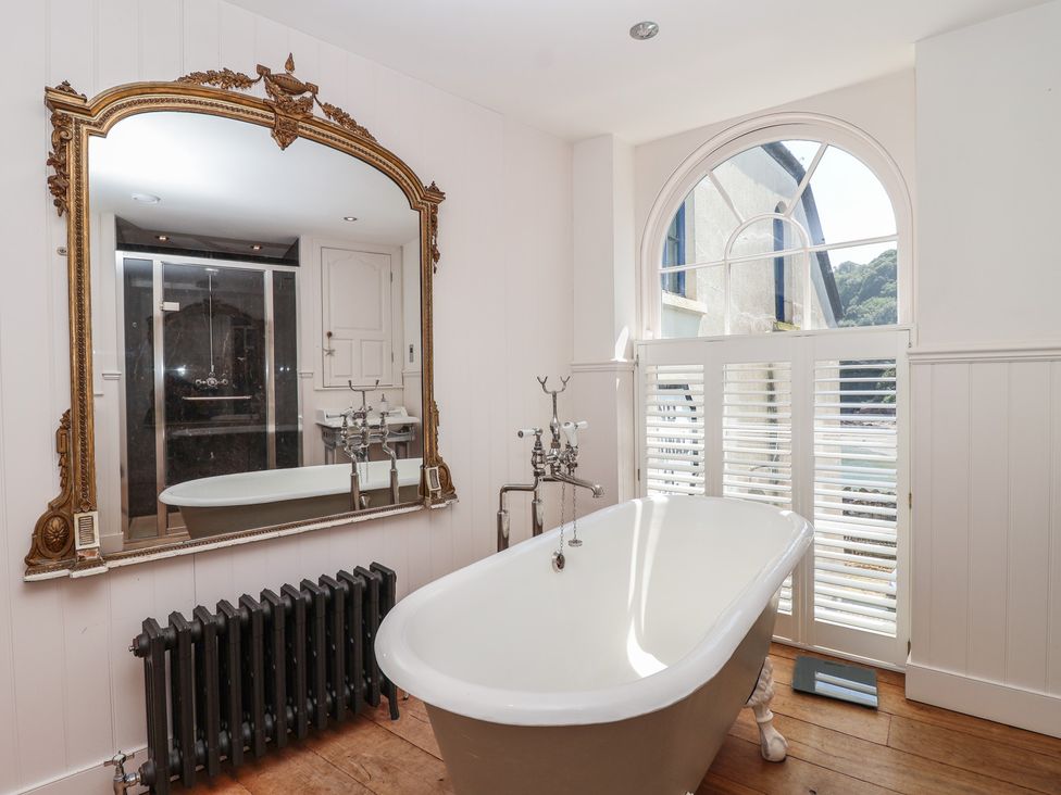A bathroom with a bathtub and mirror at Marina