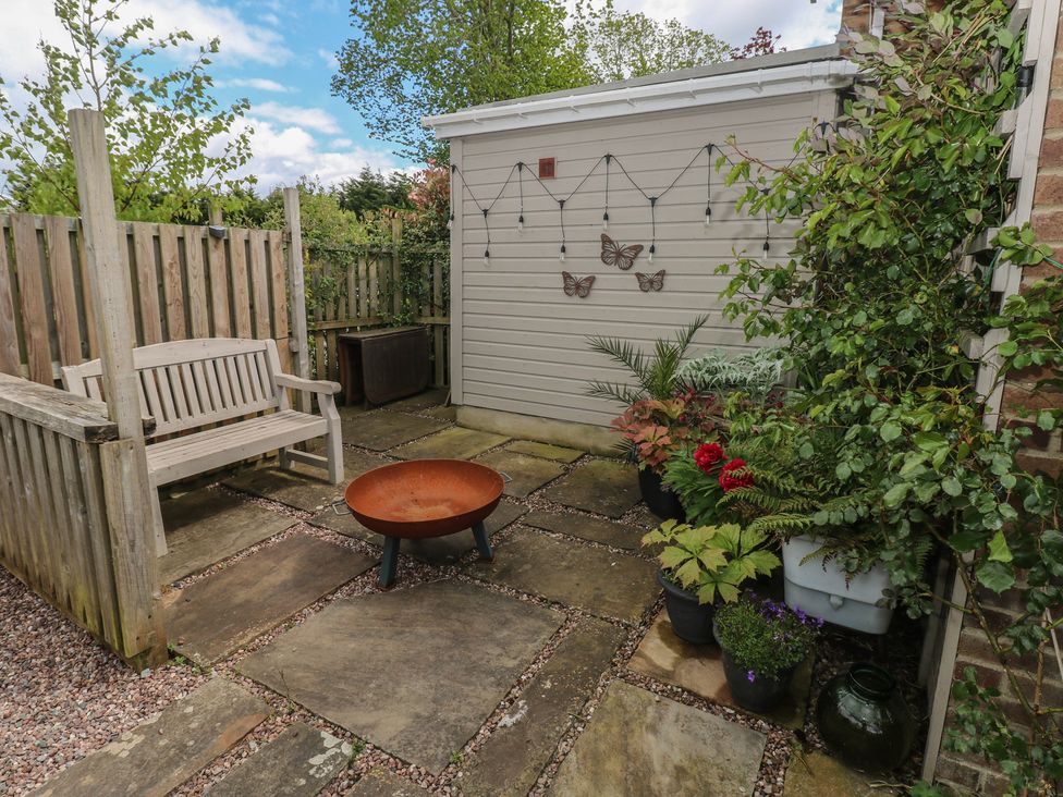 A garden with a bench, fire pit, and potted plants at Garden View in Pembroke