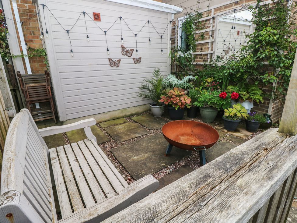 A garden with a bench and a fire pit surrounded by potted plants at Garden View in Pembroke