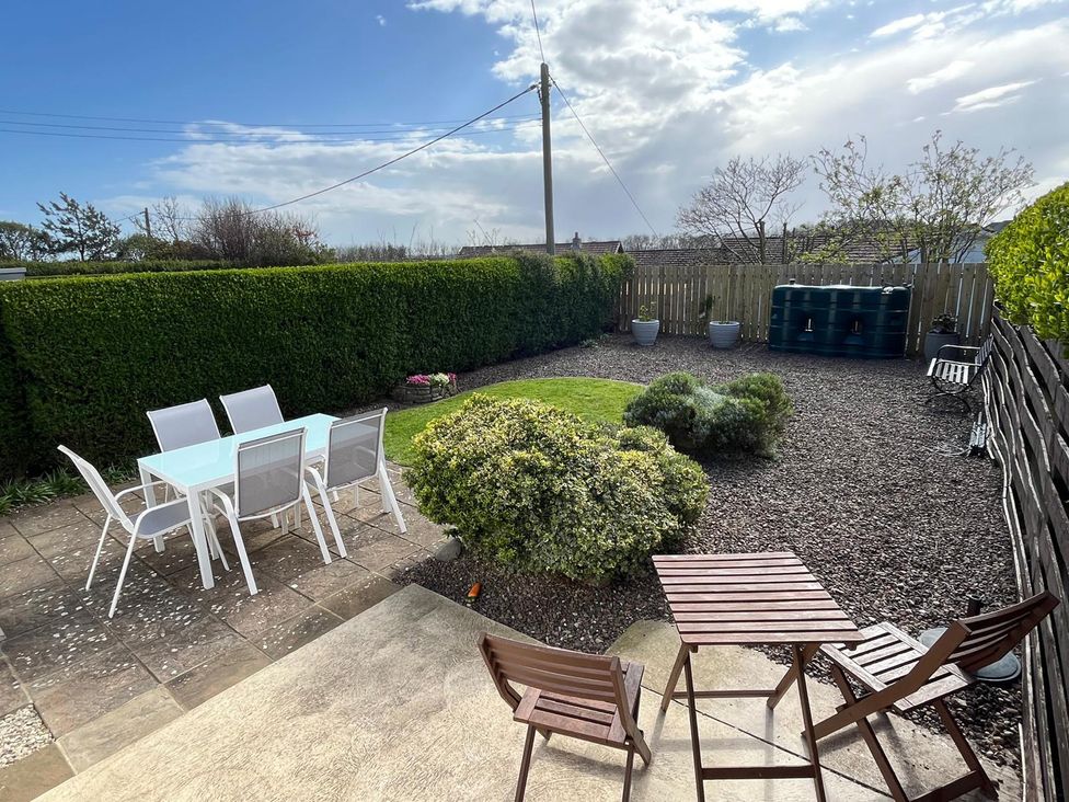 A garden with a table and chairs at Maywood in Seahouses