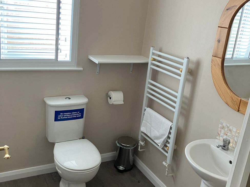 A bathroom featuring a toilet, sink, mirror and towel rail at Ludlow House in Ludlow