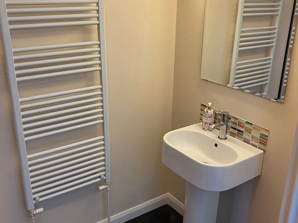 A bathroom with a sink, faucet, radiator, and mirror at Ludlow House in Ludlow