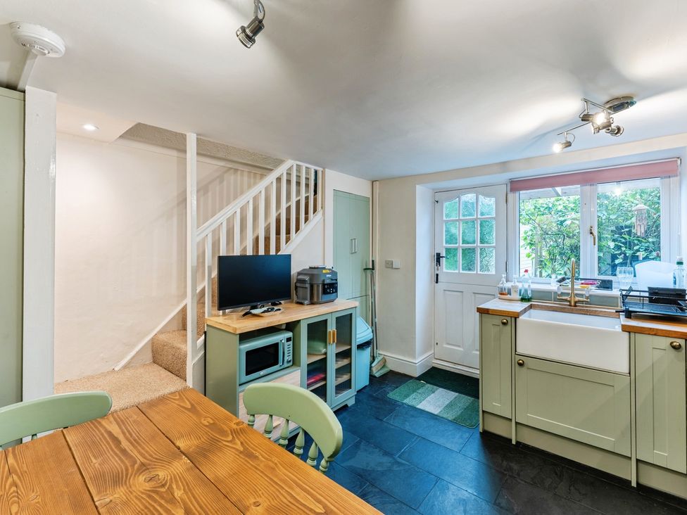A kitchen with a table and TV at Rivendell in Ffynnongroyw