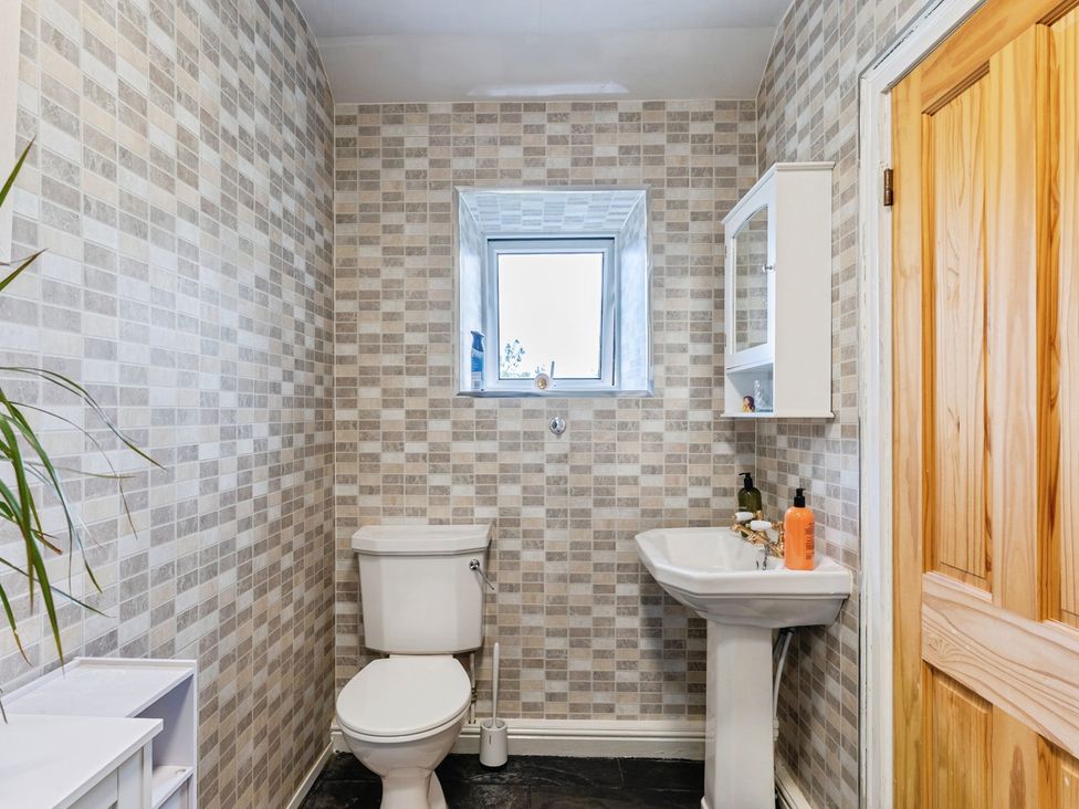 A bathroom with a toilet and sink at Rivendell in Ffynnongroyw