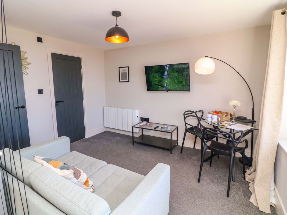 A living room with a sofa and television at Apt 8 @ Hunter's Quay in Bridlington