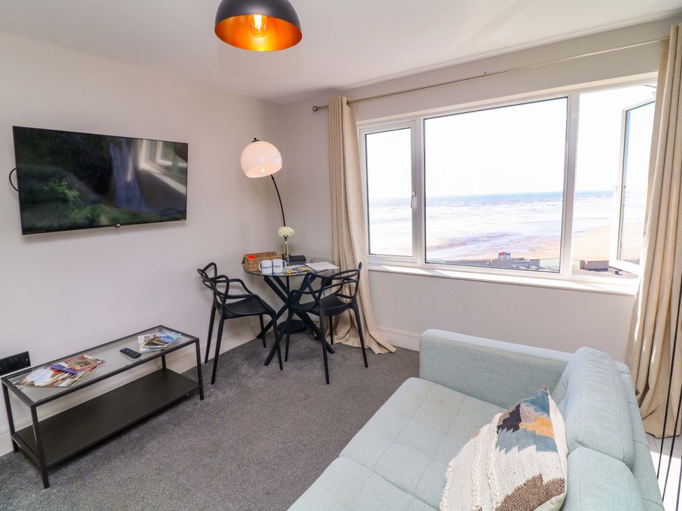 A living room with a television and a table at Apt 8 @ Hunter's Quay in Bridlington