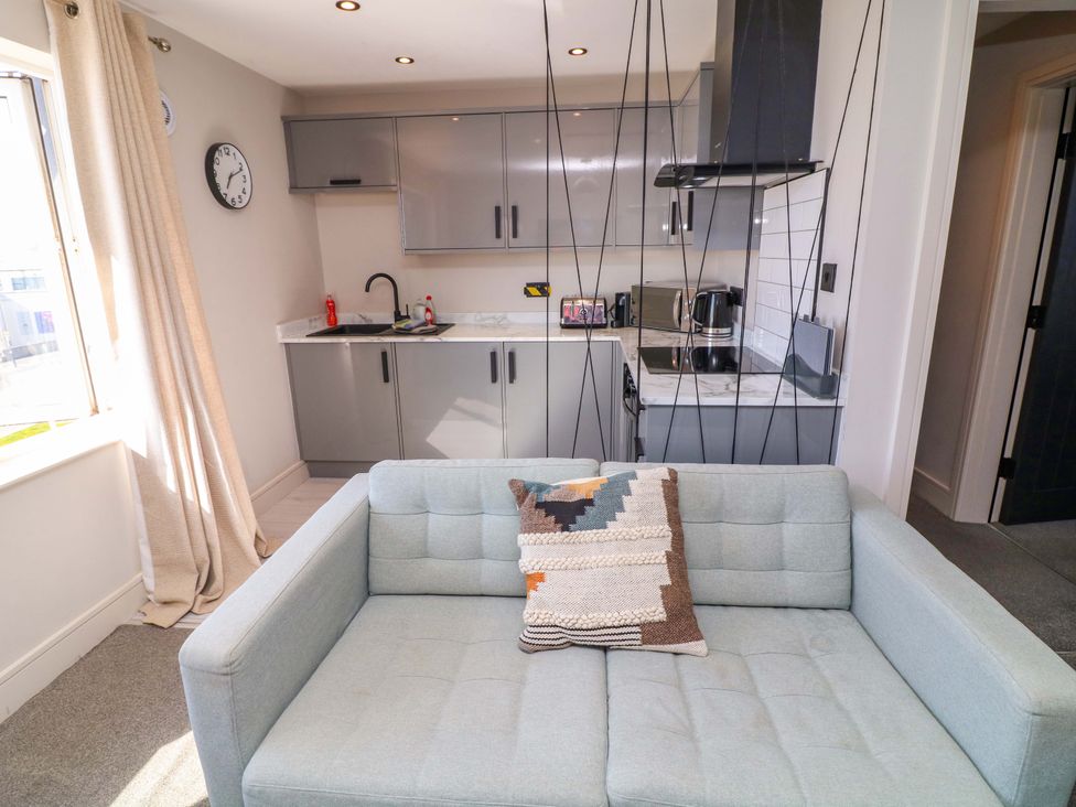 A kitchen with a sofa and clock at Apt 8 @ Hunter's Quay in Bridlington