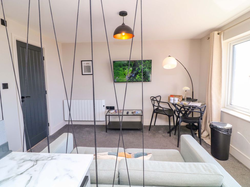 A living room with a television and a dining table at Apt 8 @ Hunter's Quay, Bridlington
