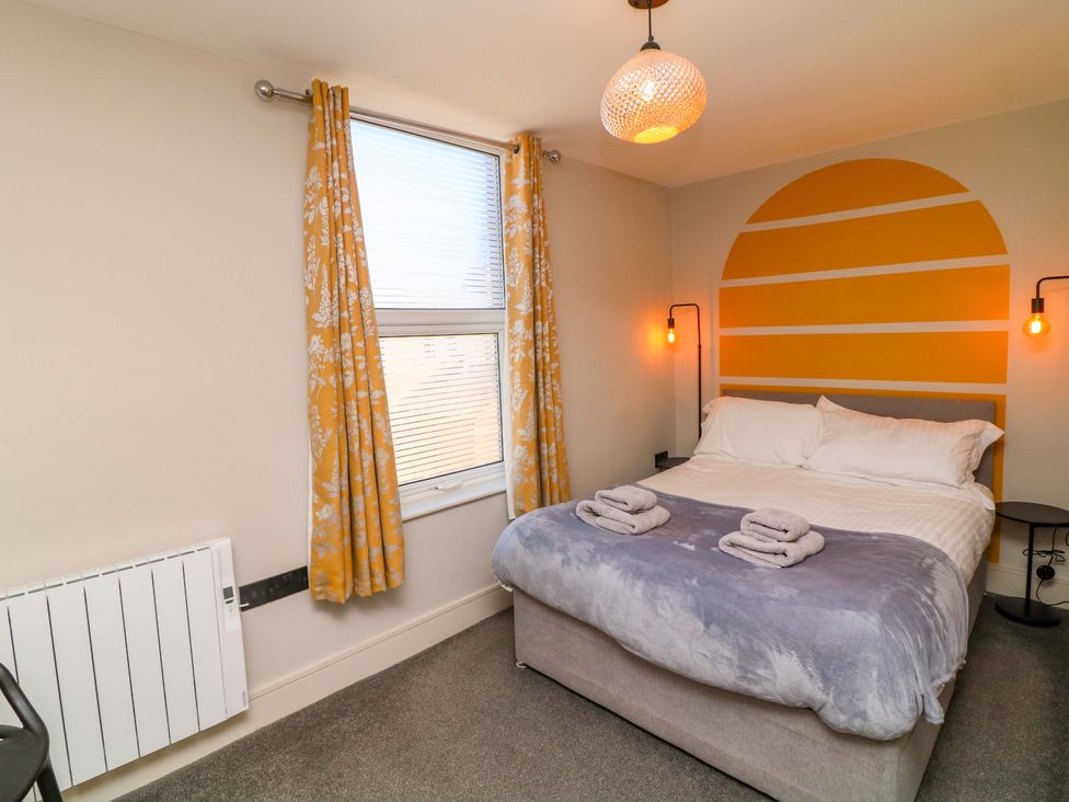 A bedroom with a bed and bedside table at Apt 8 @ Hunter's Quay, Bridlington