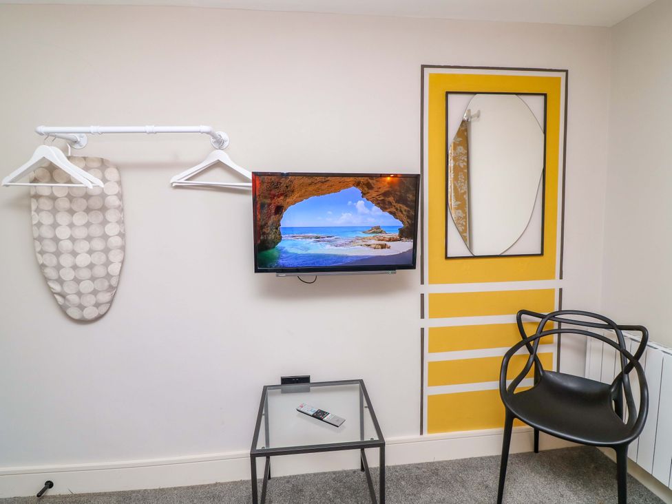 A bedroom with a television and an iron board at Apt 8 @ Hunter's Quay Bridlington