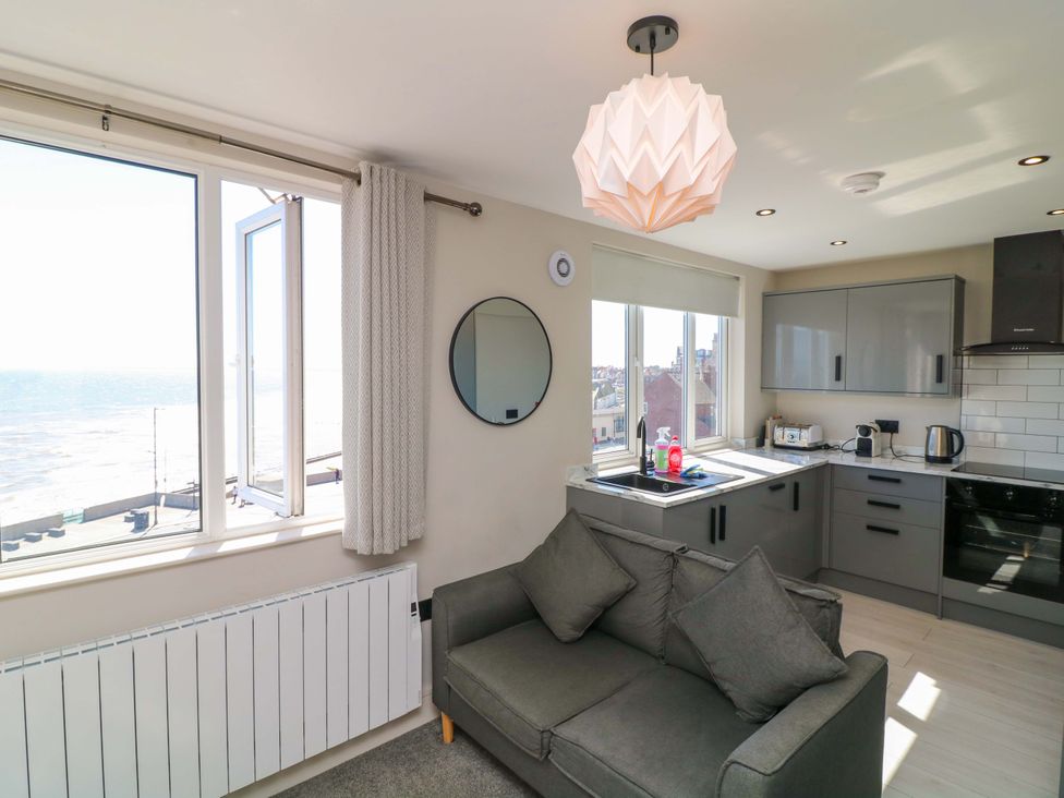 A living room with a sofa and kitchen unit at Apt 9 @ Hunter's Quay in Bridlington