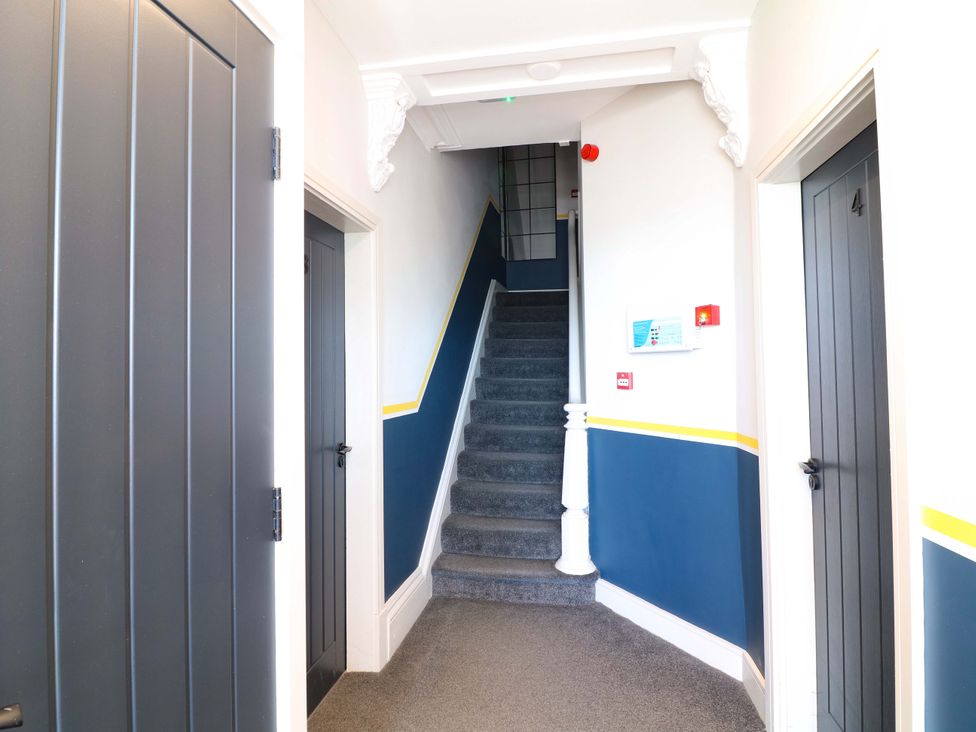 A hallway with a staircase and doors at Apt 9 @ Hunter's Quay in Bridlington