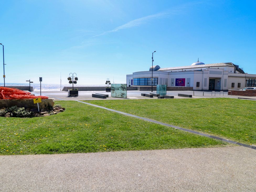 A view of a seaside area with grass and a building at Apt 9 @ Hunter's Quay, Bridlington