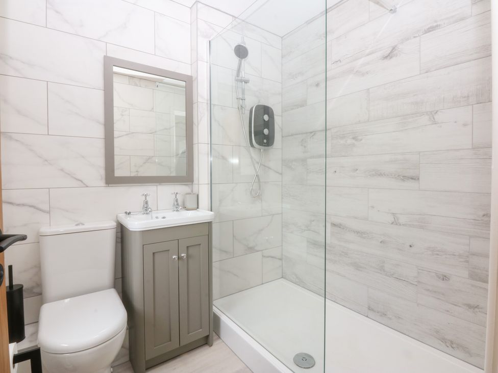 A bathroom with a shower, sink, and toilet at Trefor Ganol in Beaumaris