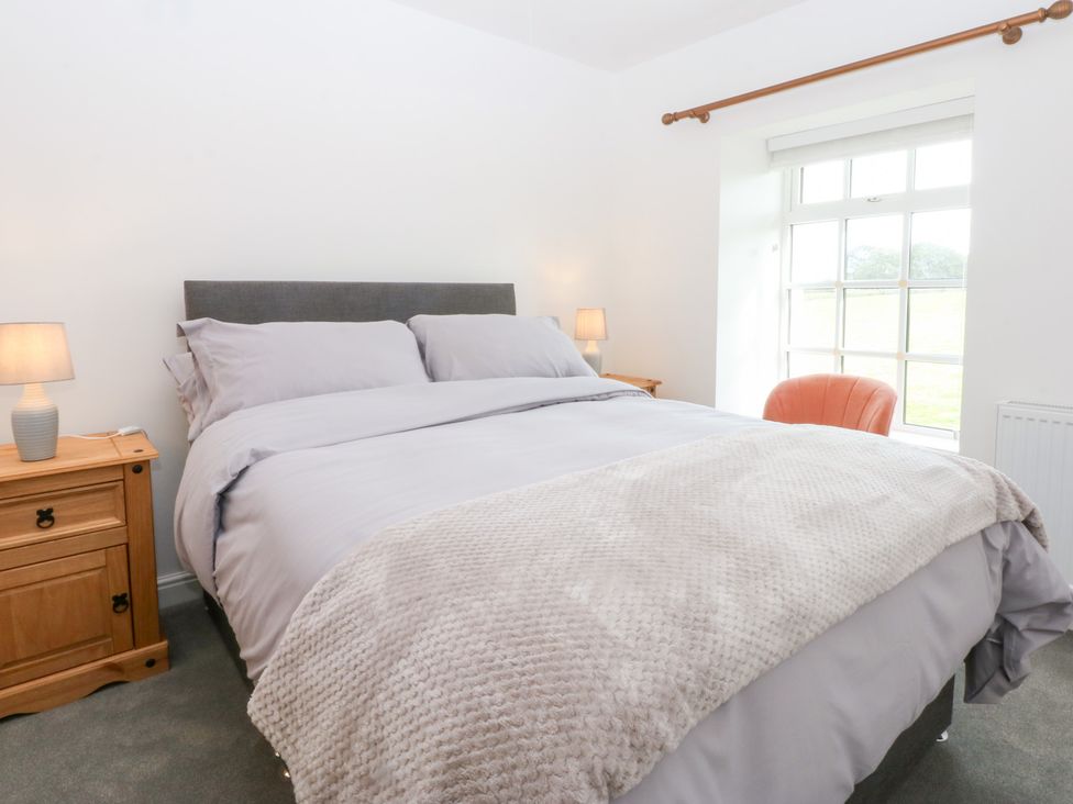 A bedroom with a bed and lamp at Trefor Ganol in Beaumaris