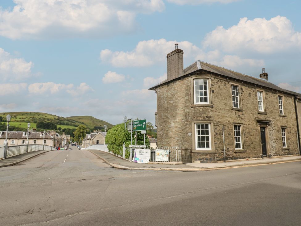 A street view with a building and road signage at Eskvale House in Langholm