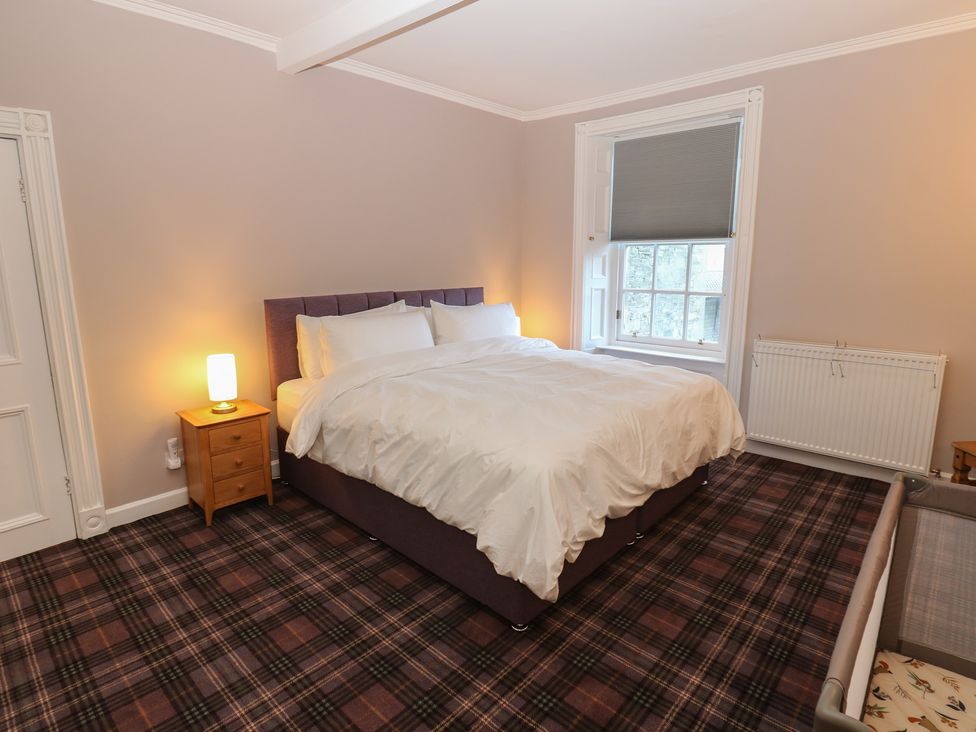 A bedroom with a bed and nightstand at Eskvale House in Langholm