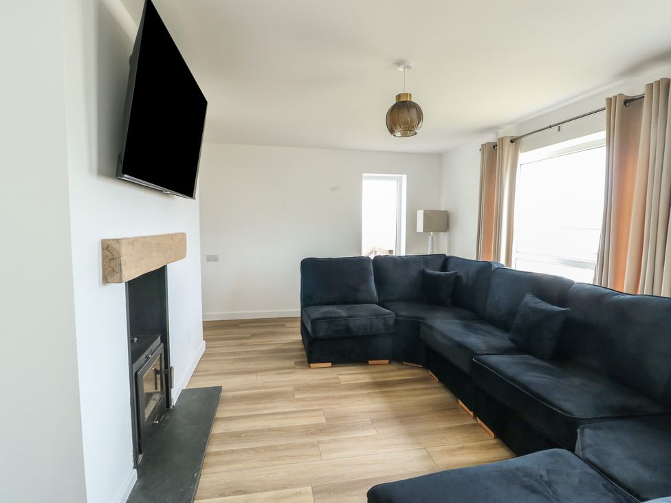 A living room with a sofa and television at 6 Gwelfor Estate