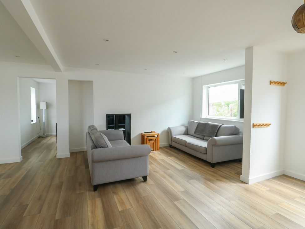 A living room with sofas and a television at 6 Gwelfor Estate