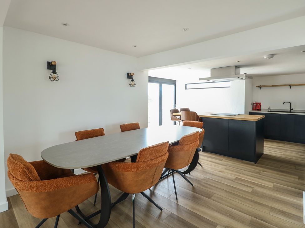 A dining room with a table and chairs at 6 Gwelfor Estate