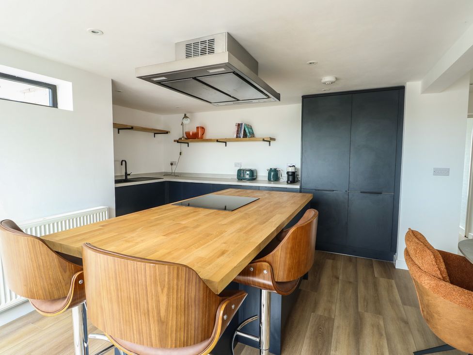 A kitchen with a central island and modern appliances at 6 Gwelfor Estate