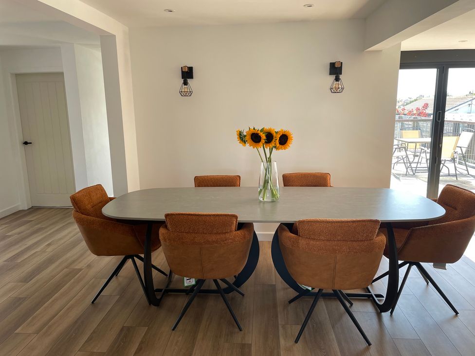A dining room with a table and chairs at 6 Gwelfor Estate Cemaes Bay