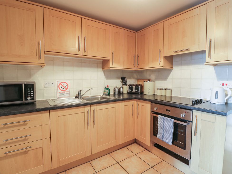 A kitchen with cabinets and appliances at King's Apartment
