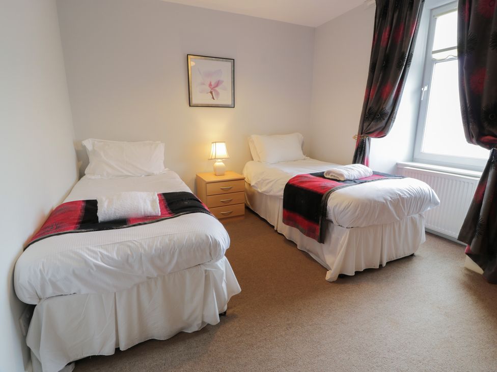 A bedroom with two single beds and a lamp at King's Apartment