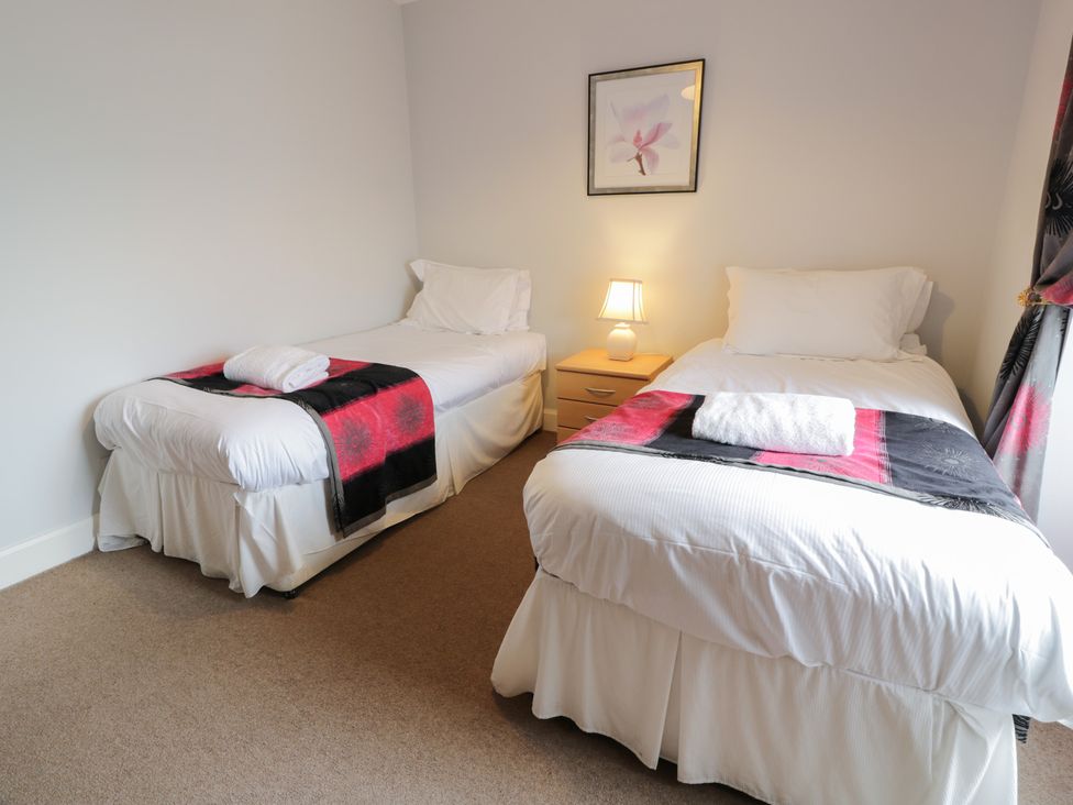 A bedroom with two single beds and a lamp at King's Apartment