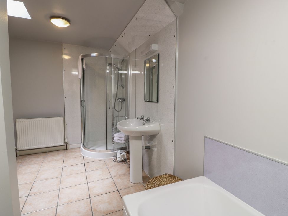 A bathroom with a shower, sink, and bathtub at King's Apartment