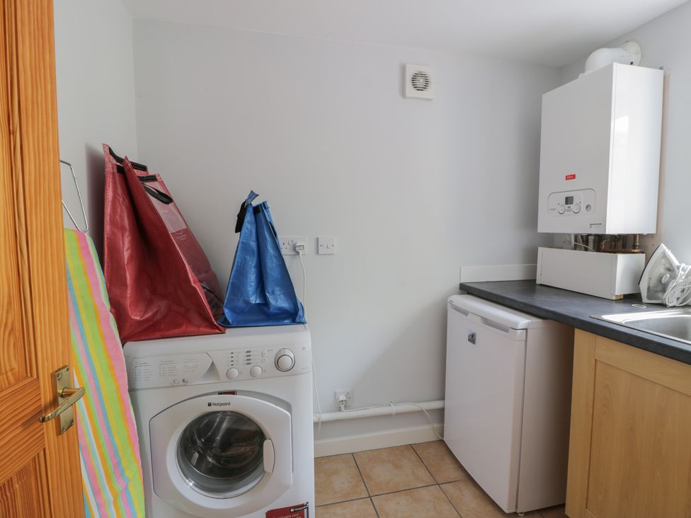 A laundry room with a washing machine and fridge at King's Apartment 