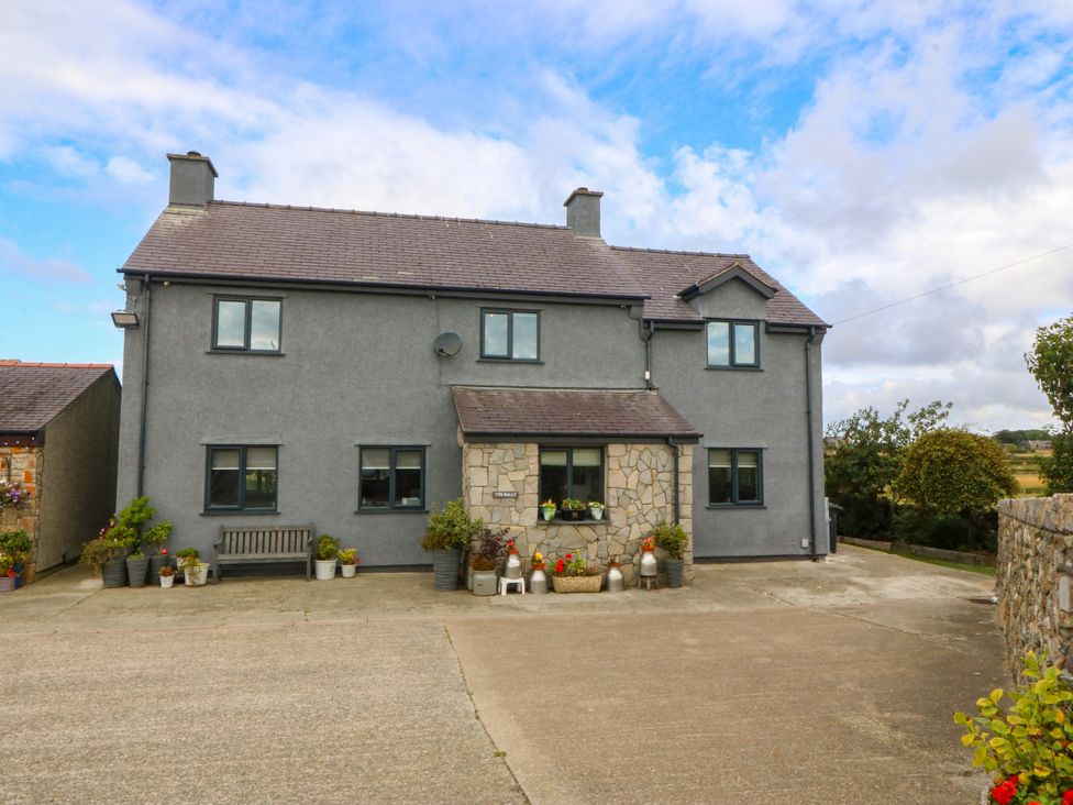 A house with a stone front and plants at Tyn Rallt Newborough