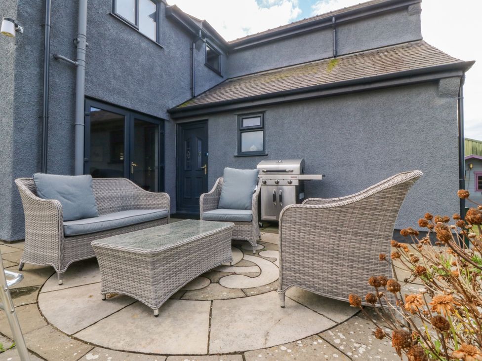 An outdoor patio with furniture and a barbecue grill at Tyn Rallt Newborough
