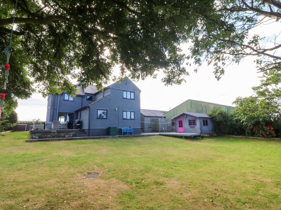 A house and shed in a garden with grass at Tyn Rallt Newborough