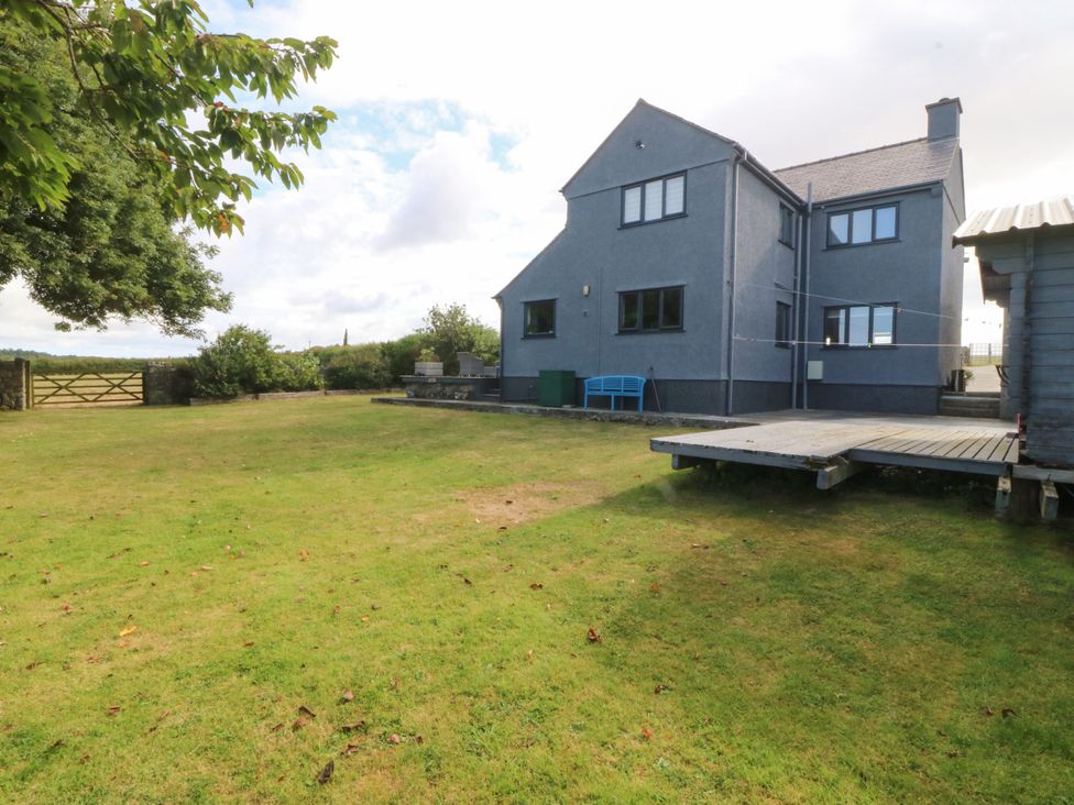 A house with a garden and decking at Tyn Rallt in Newborough