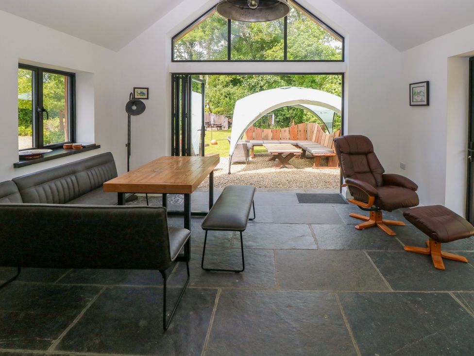 A dining room with a table and sofa at Glas y Dorlan Nevern near Newport, Pembrokeshire
