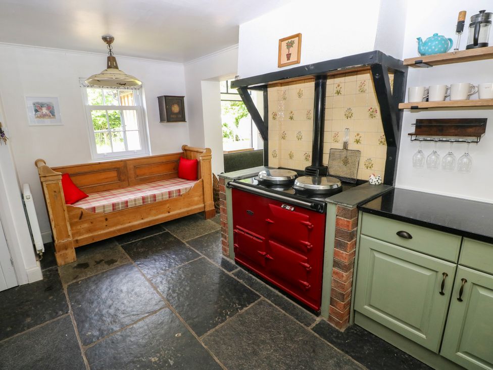 A kitchen with a red stove and a wooden bench at Glas y Dorlan near Newport, Pembrokeshire