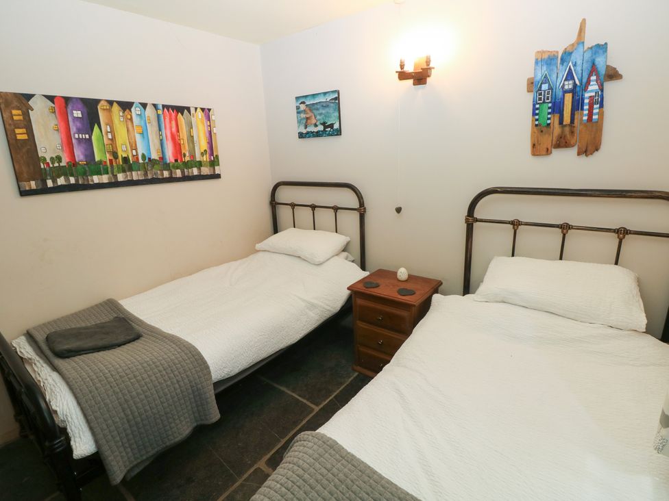 A bedroom with two beds and artwork on the walls at Glas y Dorlan in Nevern near Newport, Pembrokeshire