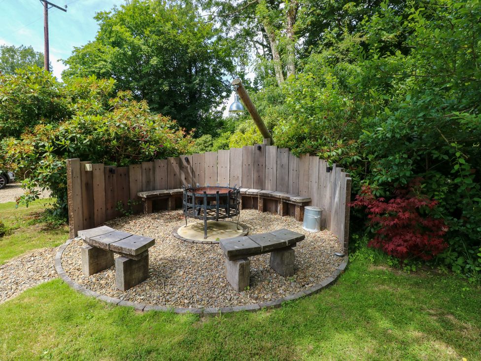 An outdoor area with a fire pit and wooden seating at Glas y Dorlan, Nevern near Newport, Pembrokeshire