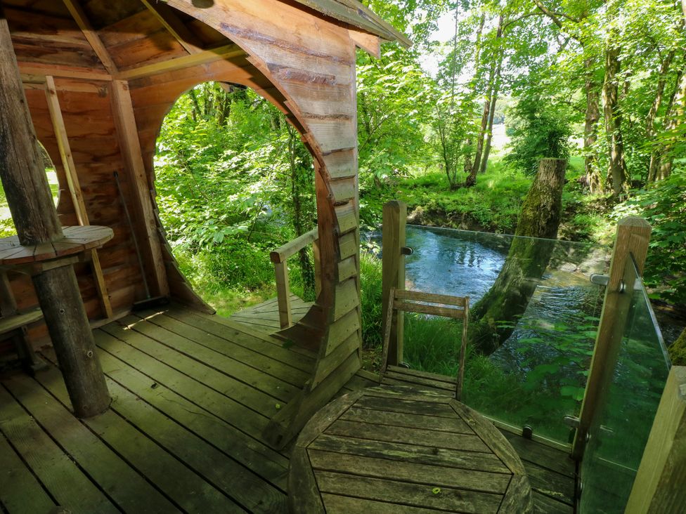 An outdoor treehouse with wooden flooring and a river view at Glas y Dorlan in Nevern near Newport, Pembrokeshire