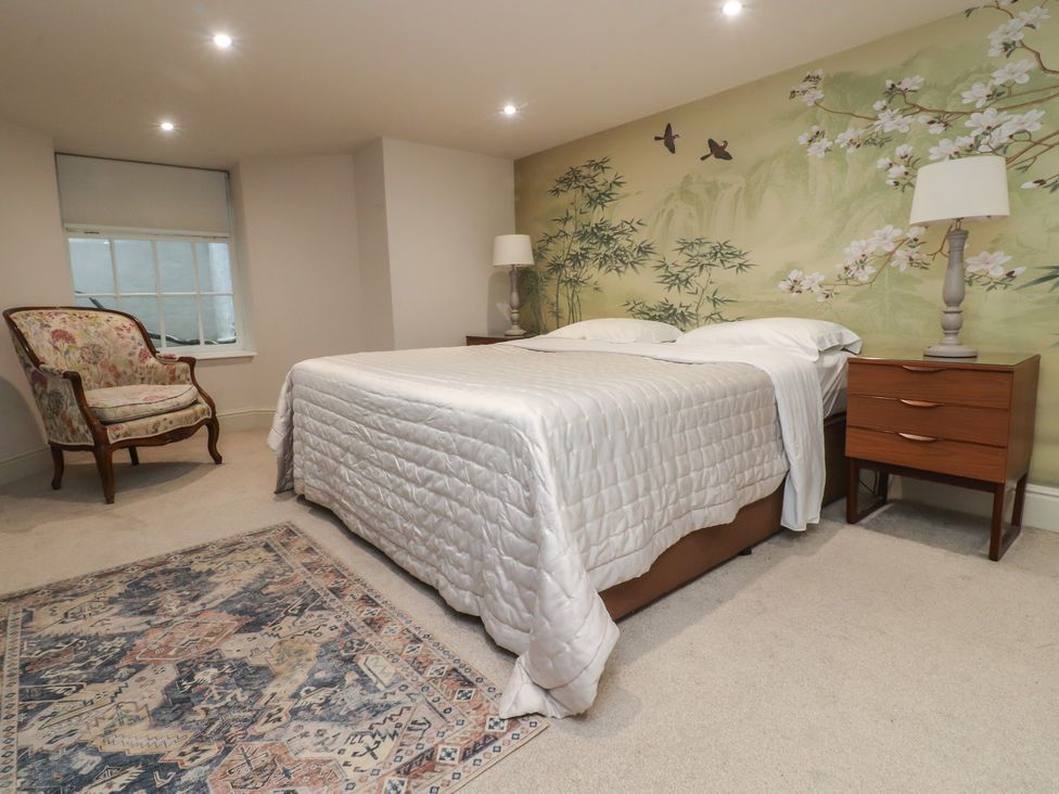 A bedroom with a bed and a chair at Paramount Apartments in Lytham St. Annes