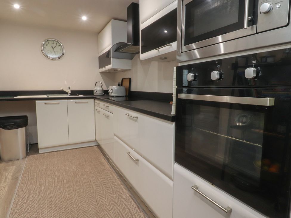 A kitchen with appliances and cabinets at Paramount Apartments in Lytham St. Annes