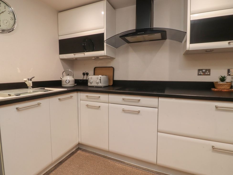 A kitchen with a sink, kettle, toaster, and cooker hood at Paramount Apartments, Lytham St. Annes