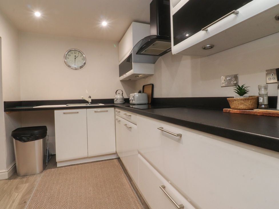 A kitchen with cabinets, sink, toaster, and kettle at Paramount Apartments in Lytham St. Annes